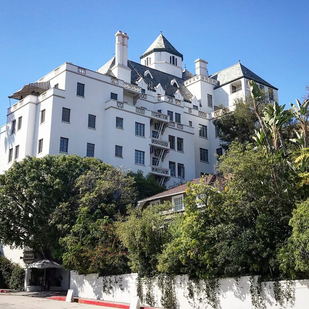 A large white building with many windows and trees