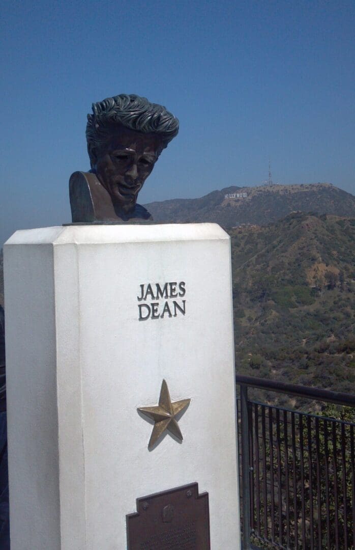 A statue of james dean is on top of the hill.