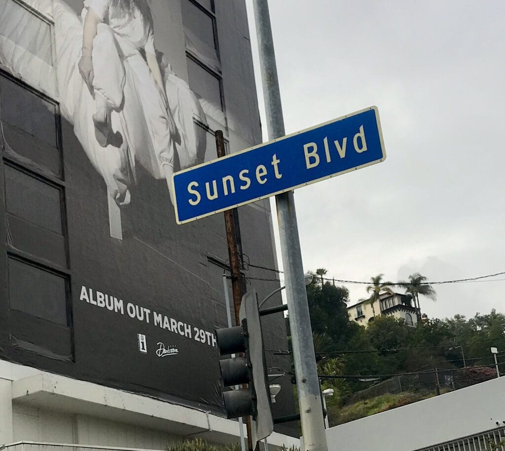 Sunset Blvd street sign with billboard background