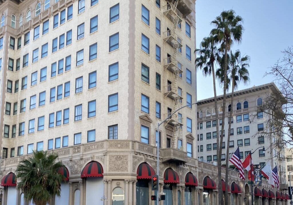 Historic hotel with red awnings and palms