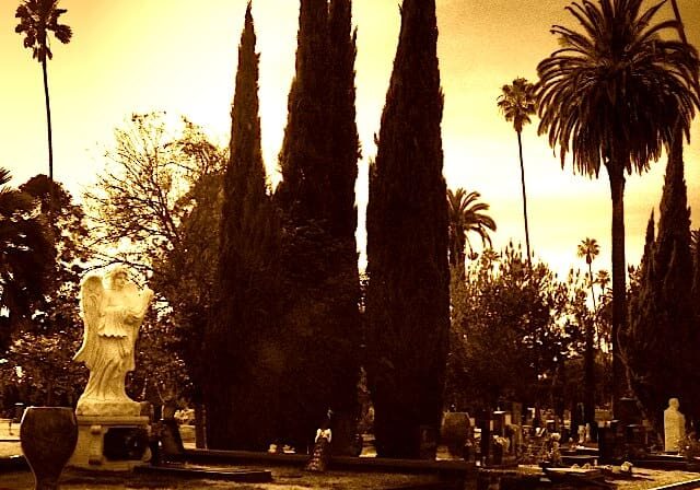 Angel statue in sepia-toned cemetery.