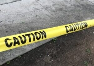Yellow caution tape across sidewalk and curb